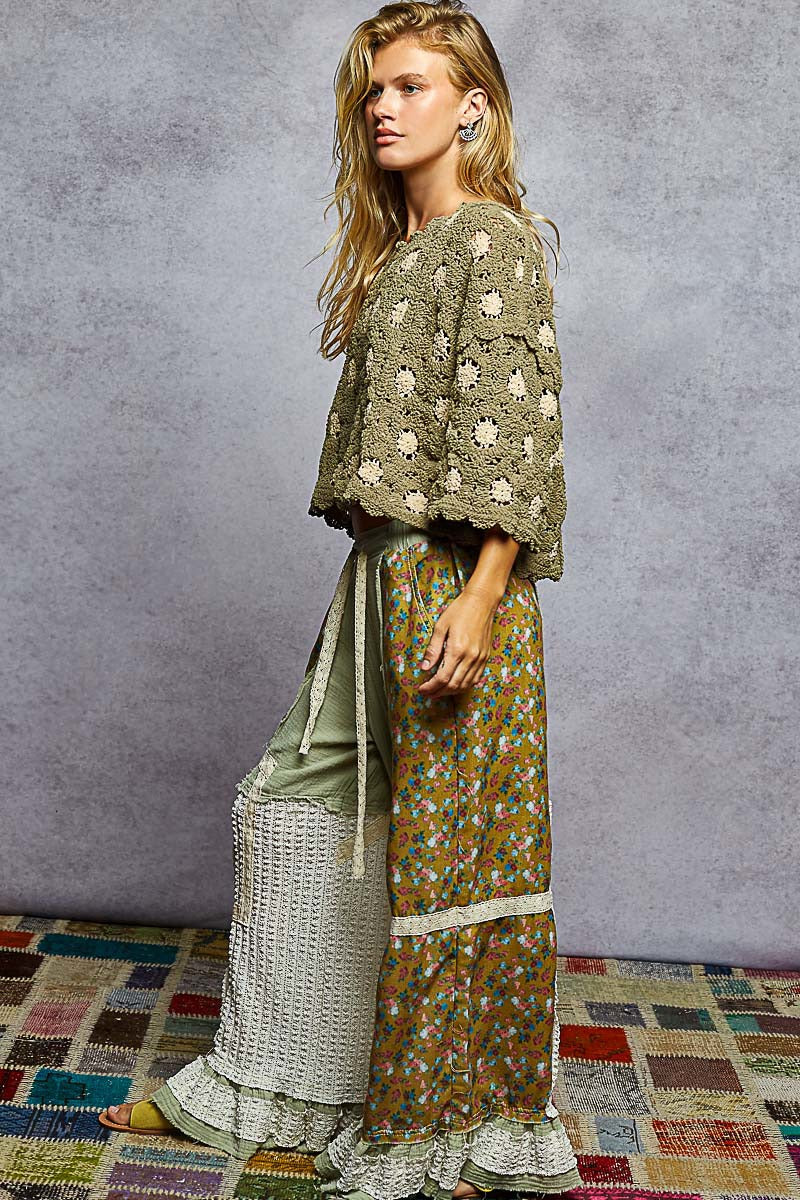 Woman wearing a floral dress and matching shawl against a textured wall.
