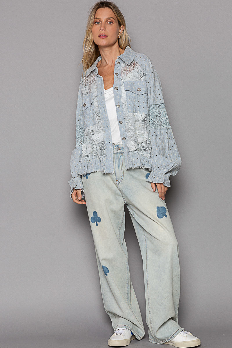 Close-up of lace patch and raw edge detailing on women's blue woven jacket top relaxed fit
