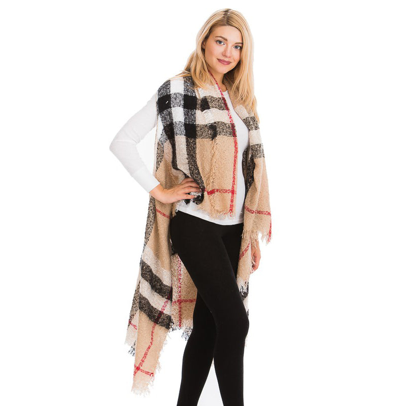 Women's plaid fringe shawl wrap styled with black trousers, neutral camel plaid woven wrap