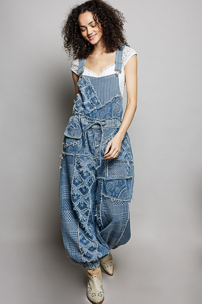 Woman wearing a patchwork denim overalls on a plain background