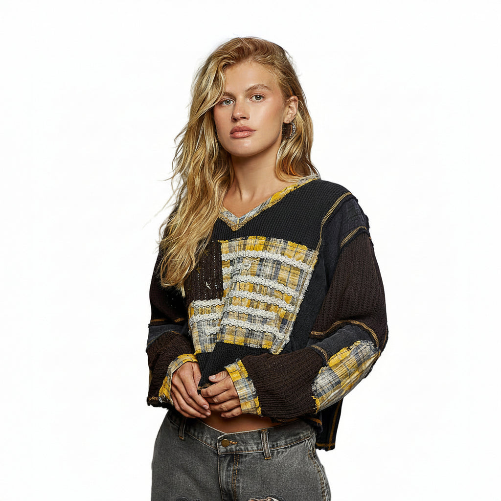 Woman wearing a black and yellow patterned sweater on a white background