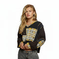 Woman wearing a black and yellow patterned sweater on a white background