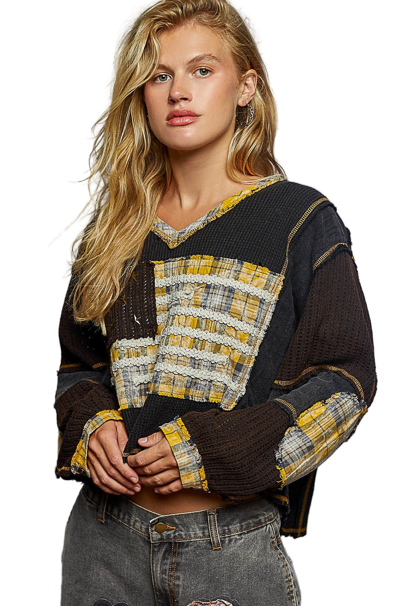 Woman wearing a black and yellow patterned sweater on a white background