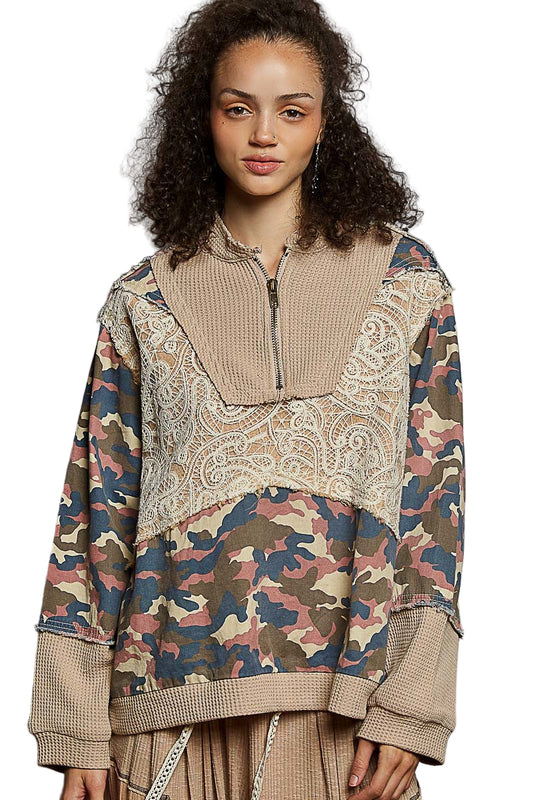 Woman wearing a patterned hoodie with camouflage design on a white background