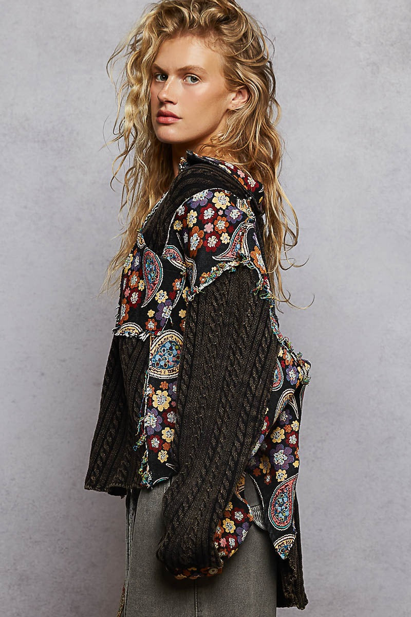 Woman wearing a patterned jacket with a plain background