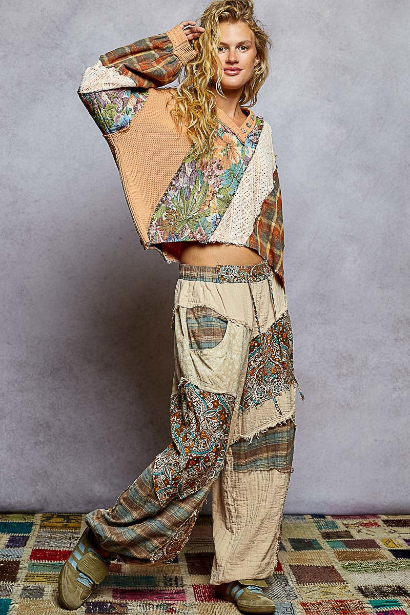 Person wearing a patchwork outfit with a textured gray background