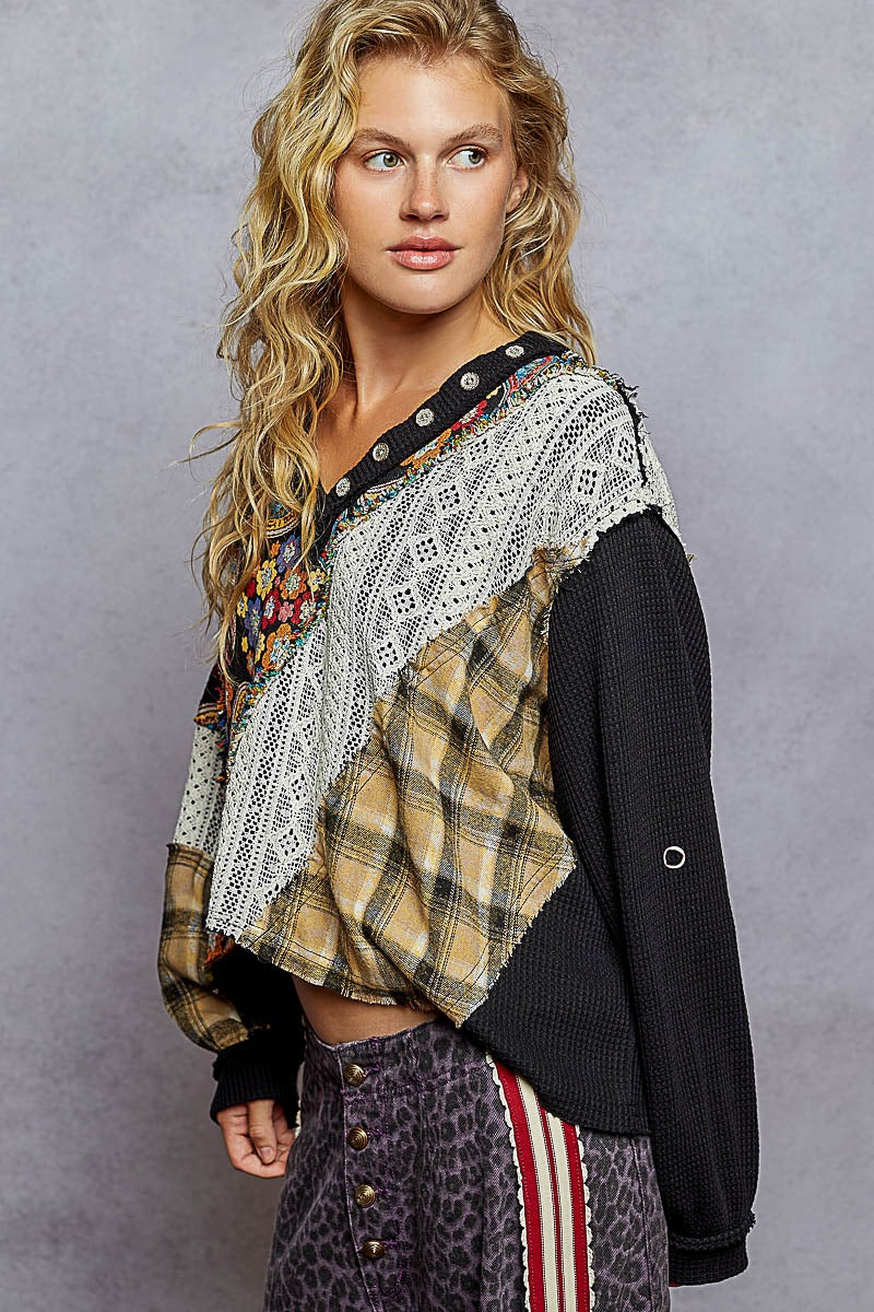 Woman wearing a plaid shirt over a patterned top with a gray background