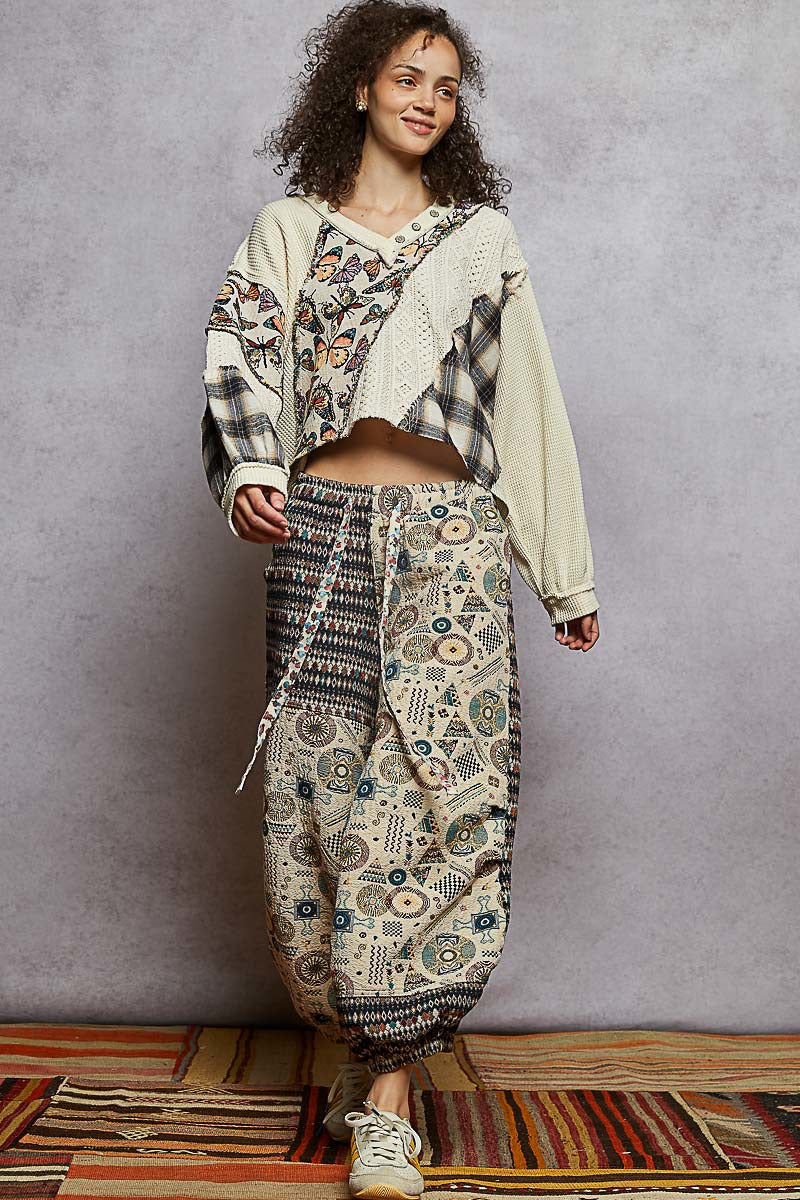 Woman wearing a patterned outfit standing against a plain background