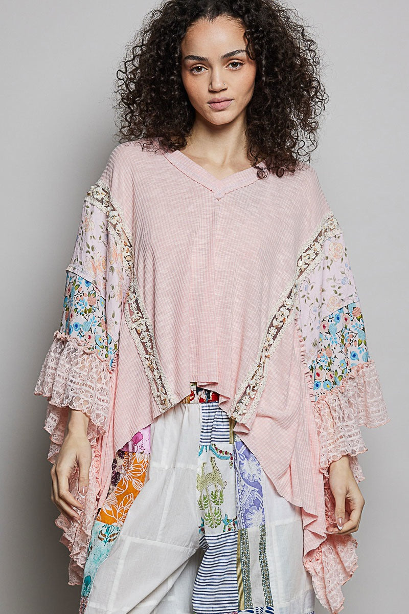 Woman wearing a pink floral kimono-style garment against a gray background