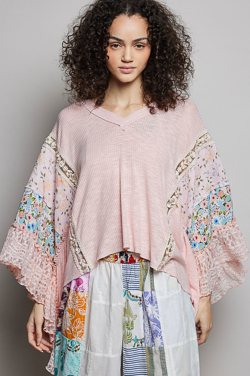 Woman wearing a pink floral kimono-style garment with a gray background