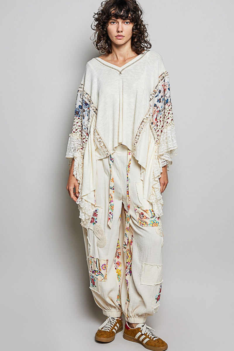 Person wearing a white outfit with floral patterns on a plain background