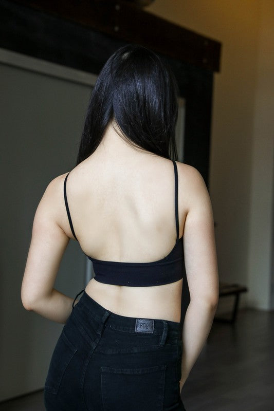 a woman in a black top is standing in a room