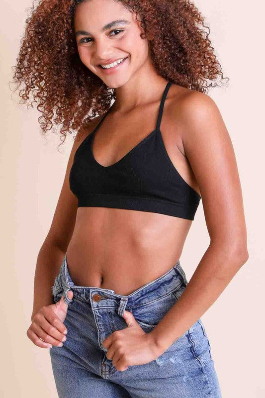 a woman with curly hair wearing a black bra top