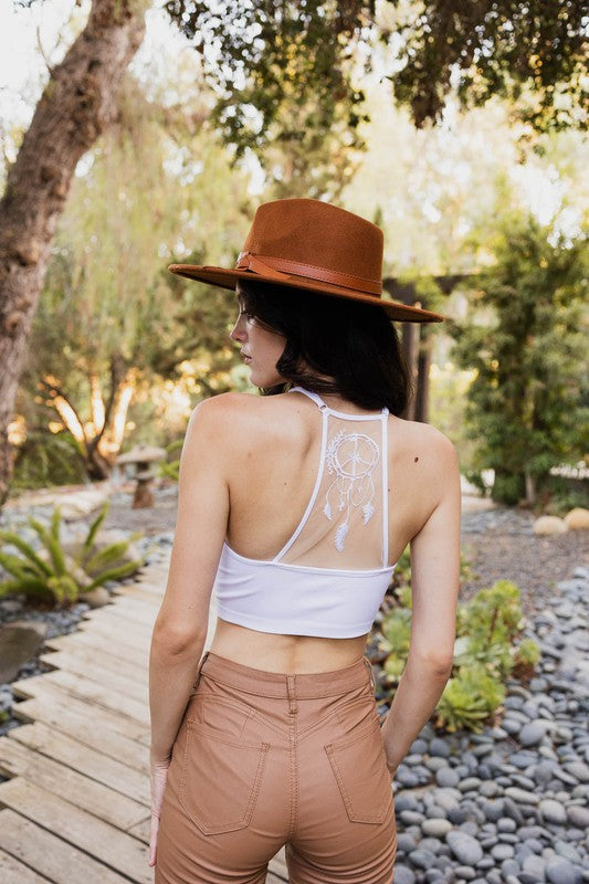 a woman wearing a brown hat and tan pants