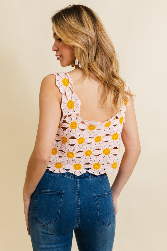 a woman wearing a pink top with yellow flowers on it