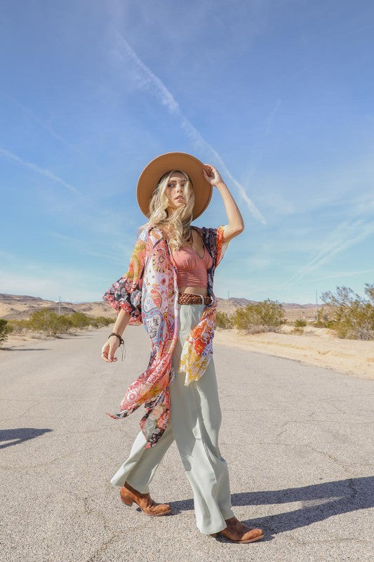 a woman in a hat is standing in the middle of the road