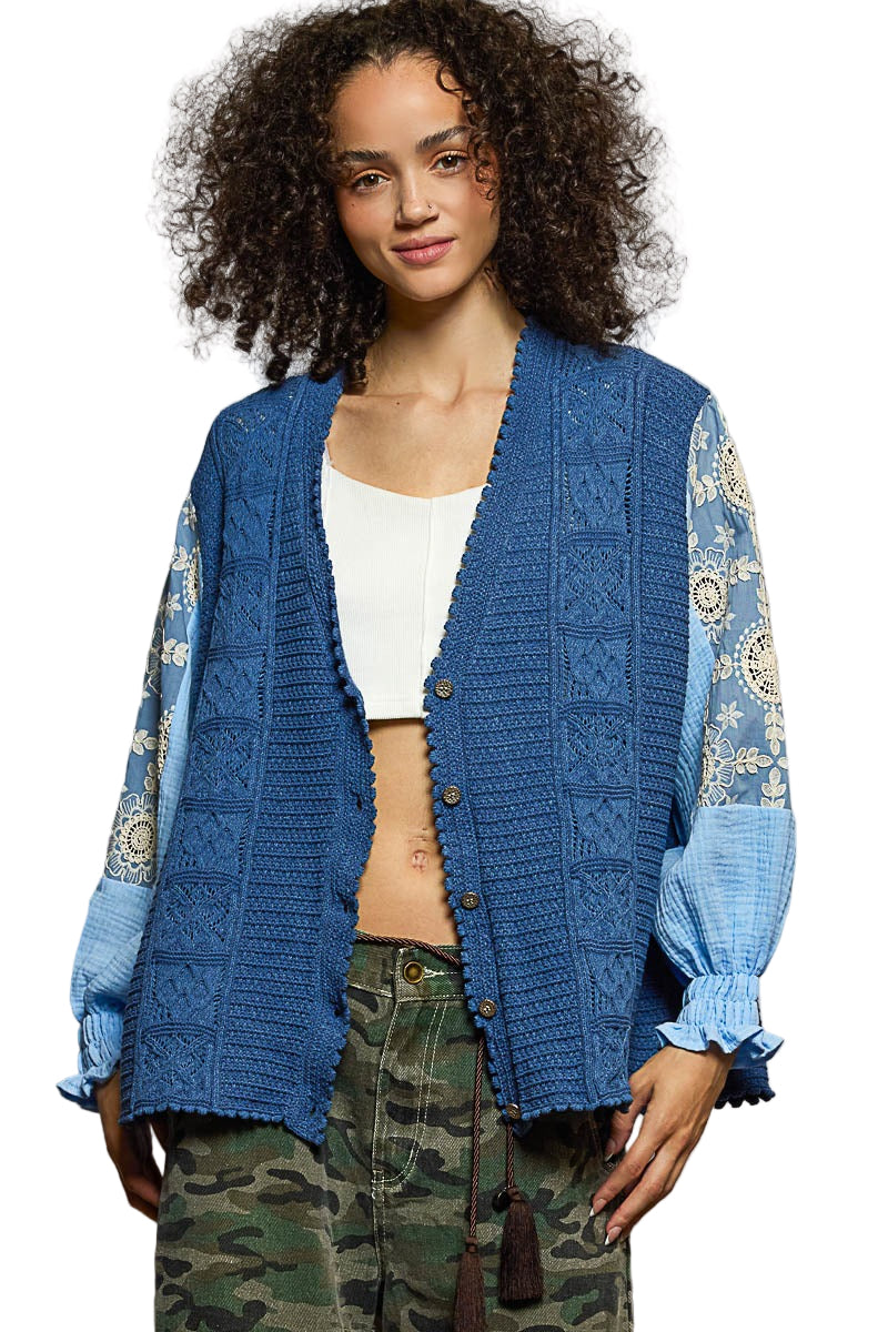 Woman wearing a blue cardigan with patterned sleeves on a white background