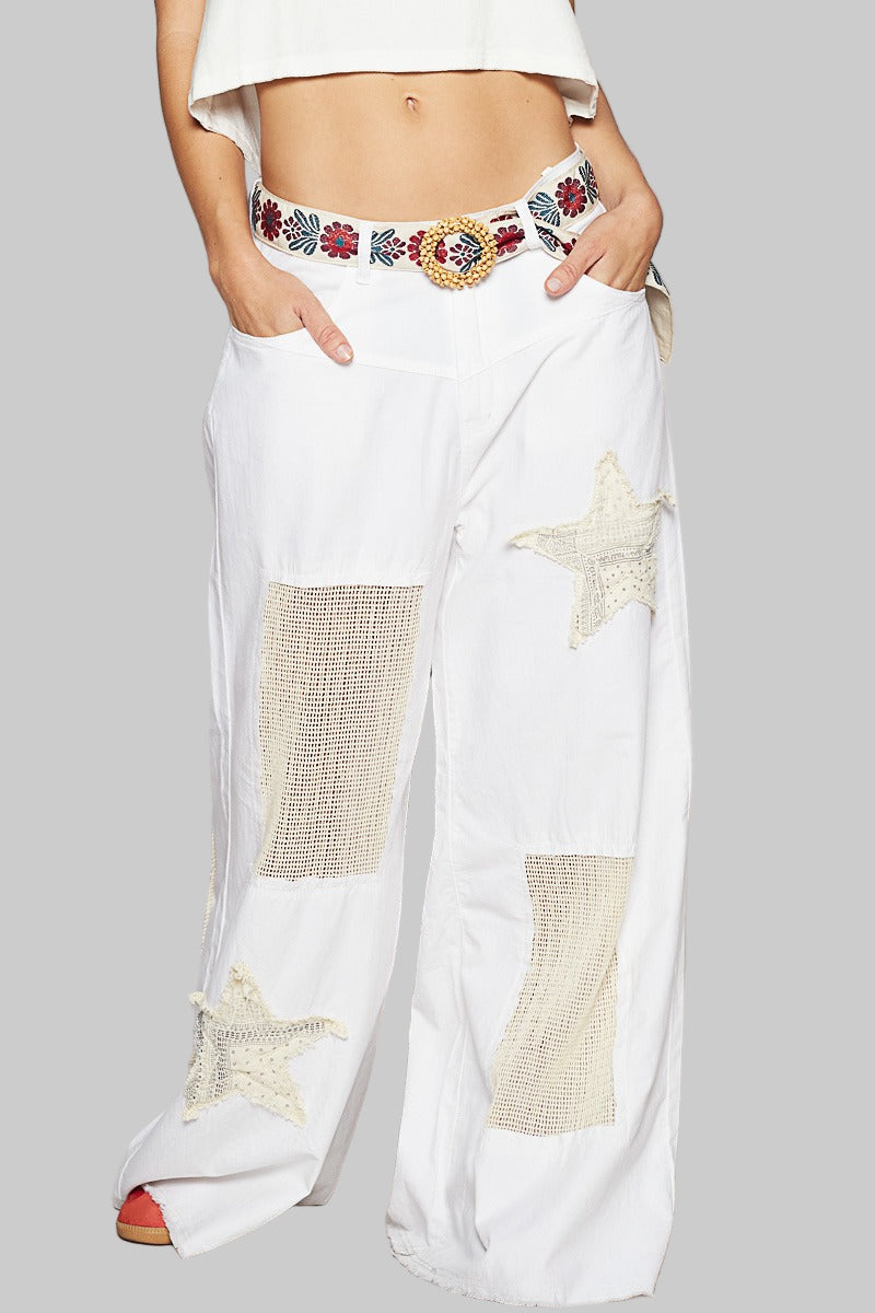 White pants with star patterns and a decorative belt on a gray background