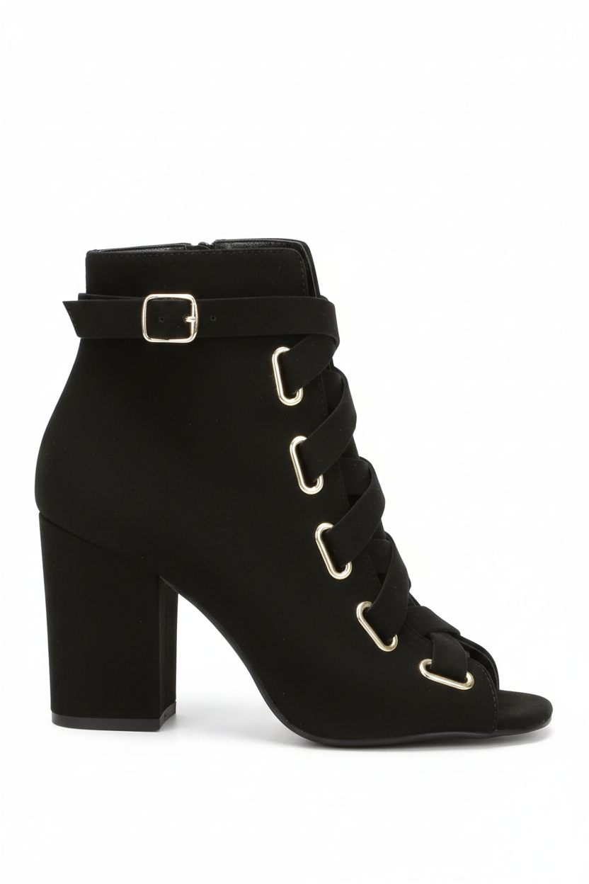 Black ankle boot with gold buckles on a white background