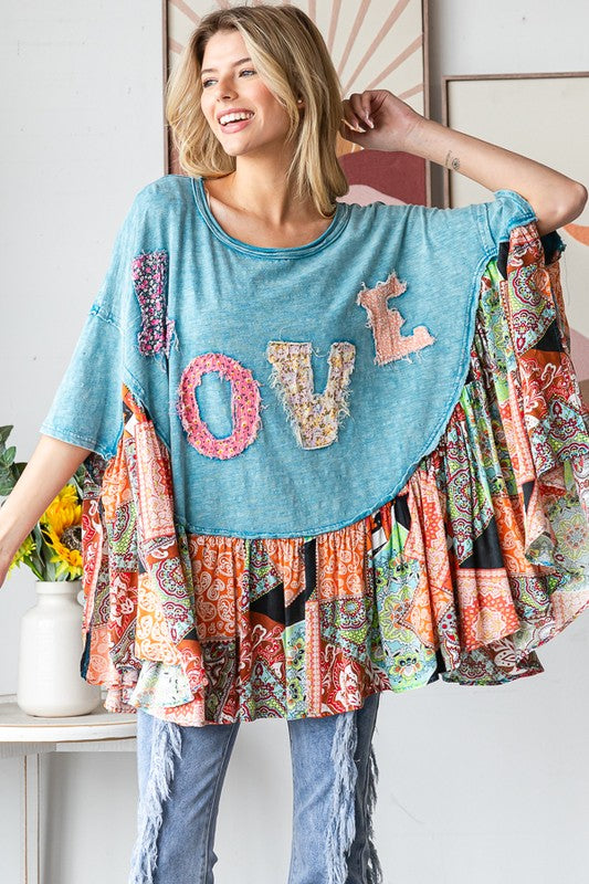 Woman wearing a colorful, patchwork-style top with 'LOVE' letters in various colors.
