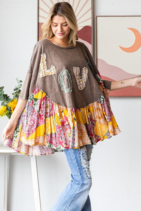 Woman wearing a brown sweater with 'LOVE' sequins and a colorful skirt in a room.