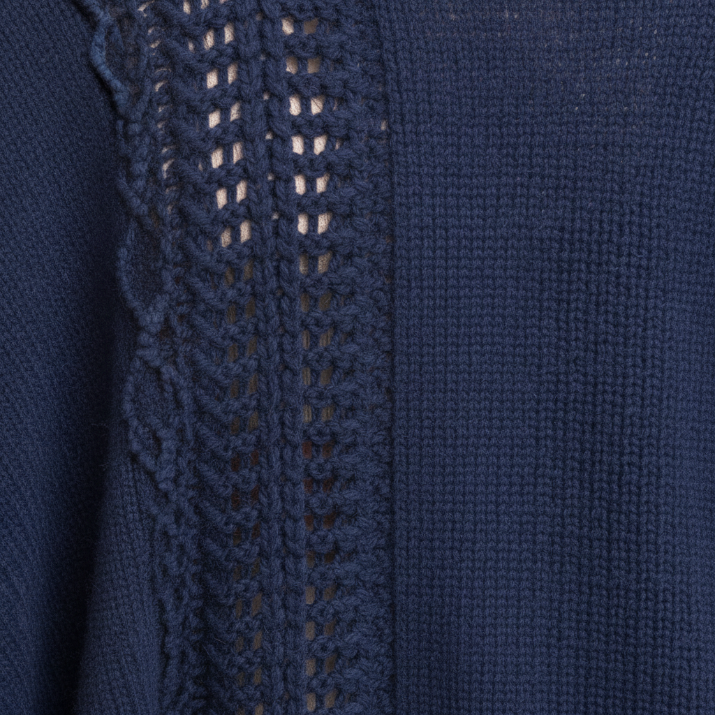 Women's navy ruana wrap close-up, ladder-stitch knit panel and long frayed fringe trim texture