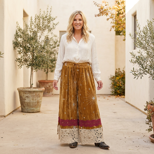 A Rare Bird Shop women's gold star-embroidered velvet pantaloons with ivory blouse in courtyard - BellanBlue