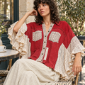 POL Clothing women's ruby red lace shirt with ruffled sleeves, seated at outdoor cafe