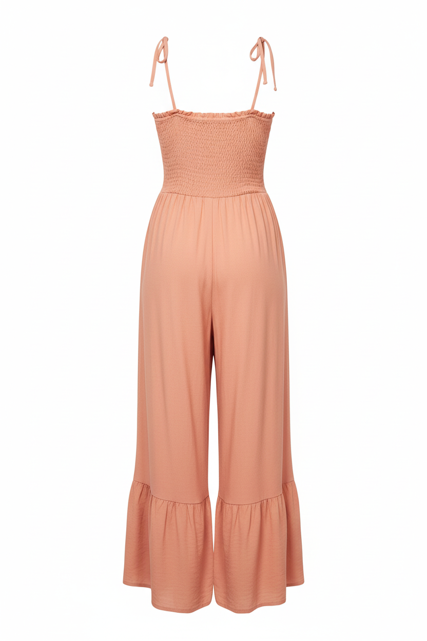 Smocked ruffle jumpsuit in coral - back view with thin tie shoulder straps and single ruffle hem