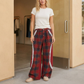 Wine plaid wide-leg pants with curved ivory lace, styled with a white tee outside a modern boutique