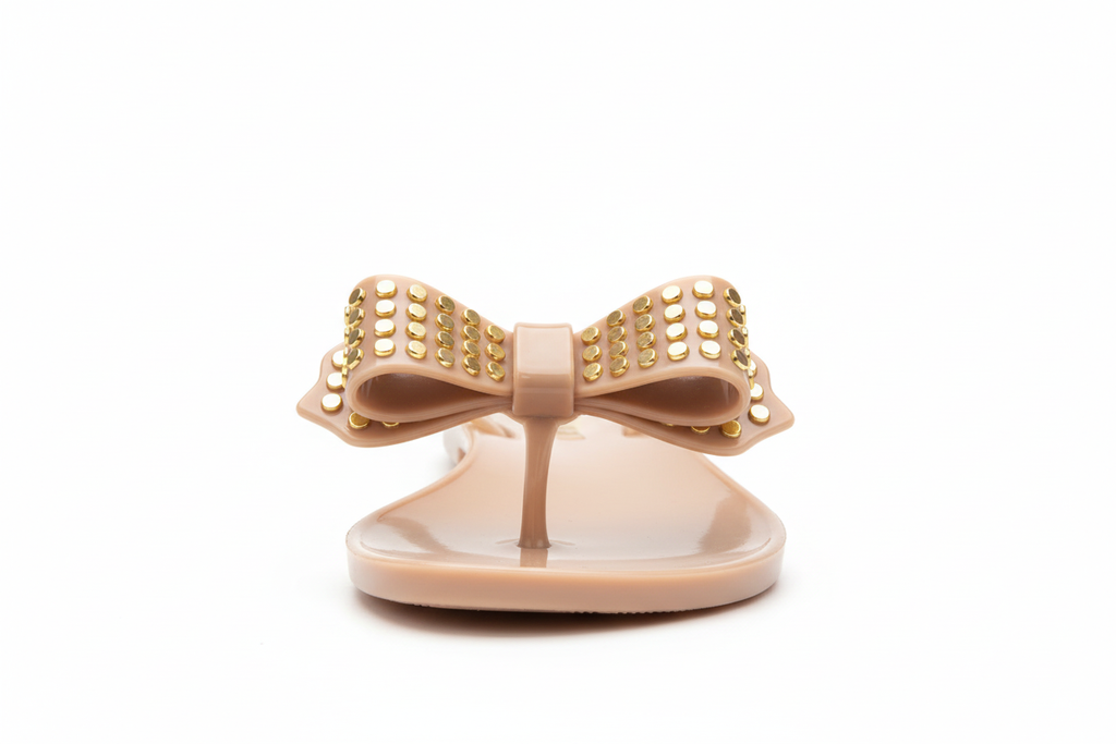 Wild Diva nude studded bow jelly sandals front view - beige flat thong sandals with gold studded bow embellishment