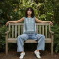 Women's denim blue crochet lace crop top seated pose showing garment drape and volume