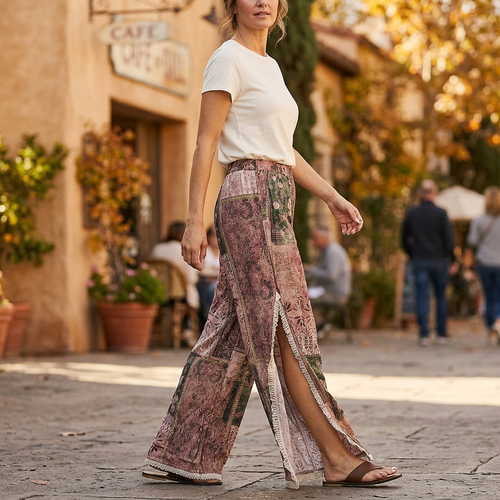 POL Clothing women's Rose Multi wide-leg pants with lace-trimmed side slits, walking outside a cafe