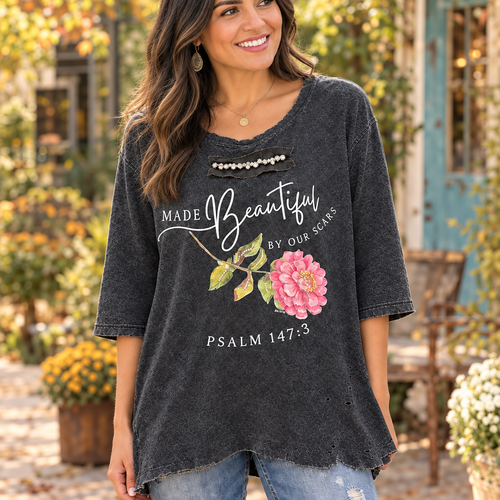 A Rare Bird Shop charcoal tee pink flower, Psalm 147:3 print and tattered hem, worn in a courtyard