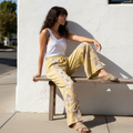 POL Clothing mineral wash wide-leg pants with floral patchwork panels, outdoor café brunch, side view