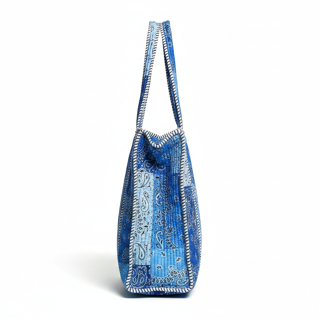 Women's quilted paisley tote bag side profile showing gusset depth and handle attachment, studio shot
