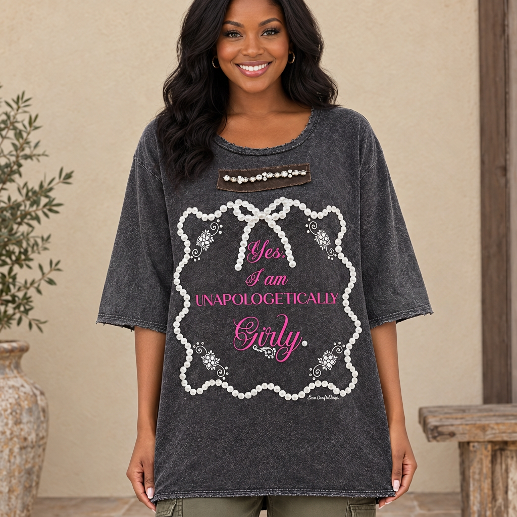 A Rare Bird Shop charcoal Girly graphic tee with sleeves past the elbow on a model standing on a porch