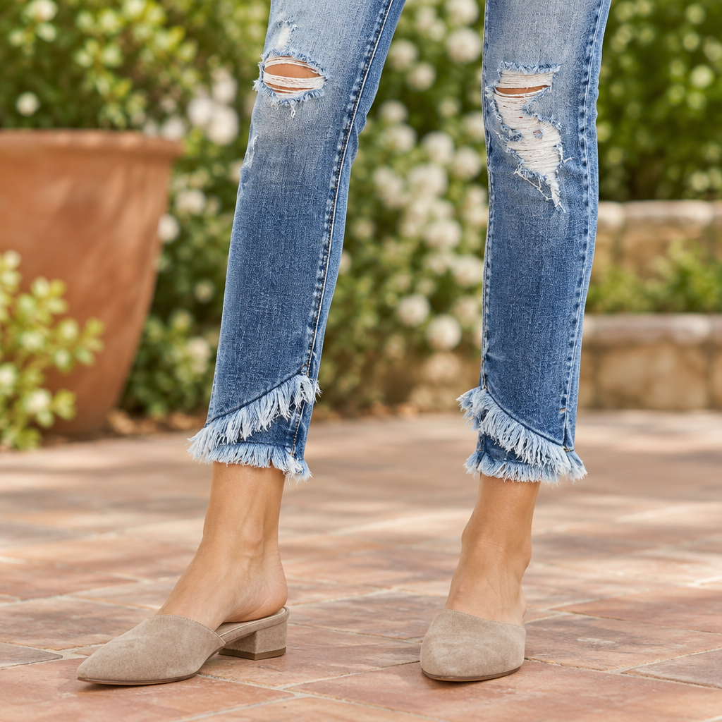 KanCan women's medium wash skinny jeans close-up of double frayed ankle hems with taupe mules