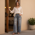 Bluevelvet women's washed denim peace patch wide-leg pants standing coffee shop entrance boutique look