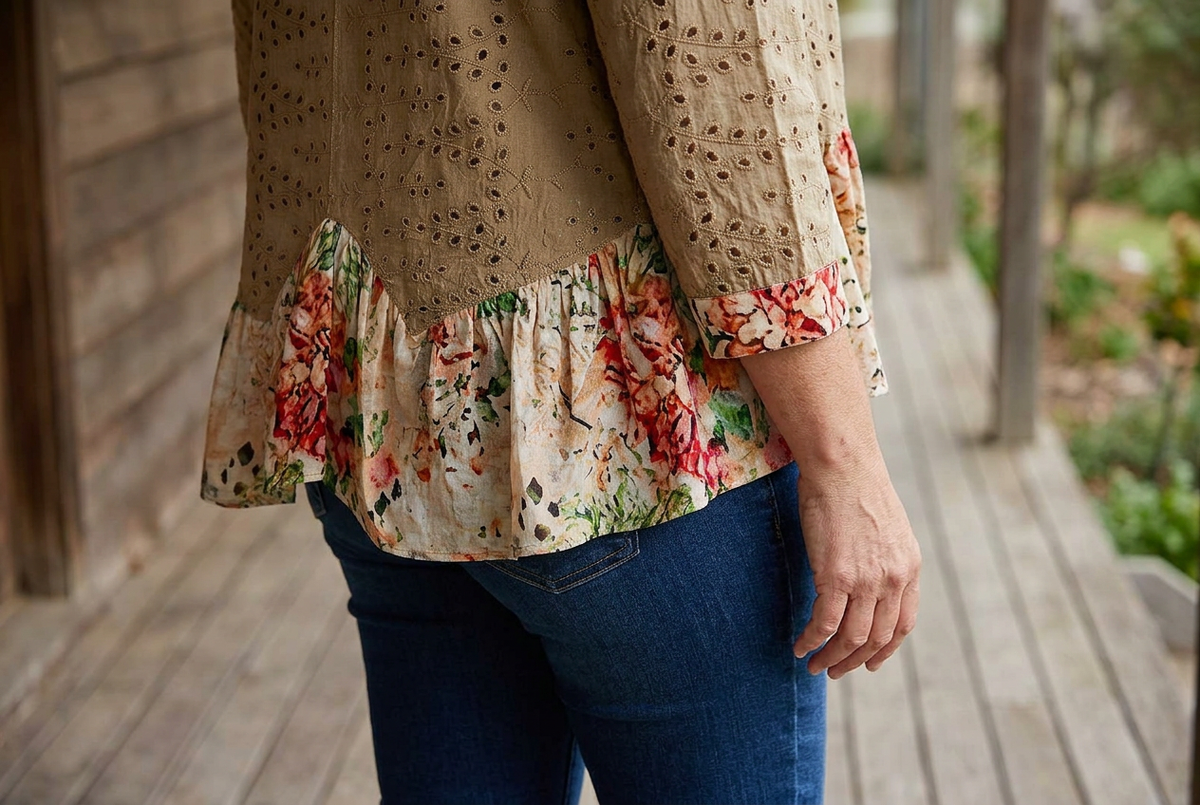 Side-back detail of mocha eyelet cardigan with gathered cream floral hem and matching printed cuff.