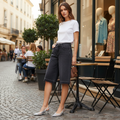 Woman standing on a street with cafe tables and people in the background