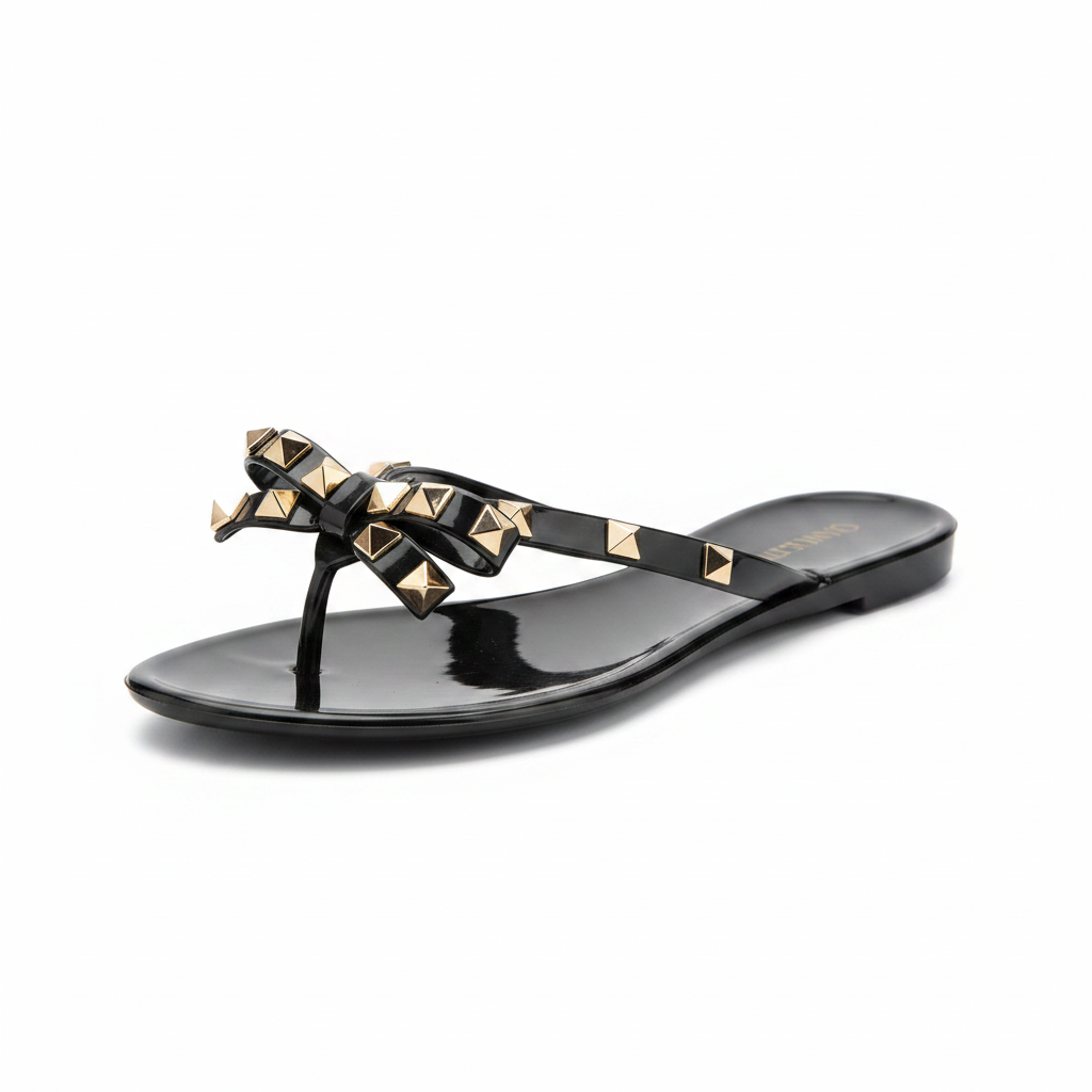 Black jelly thong sandal with gold pyramid studs and bow detail, 3/4 front view - BellanBlue