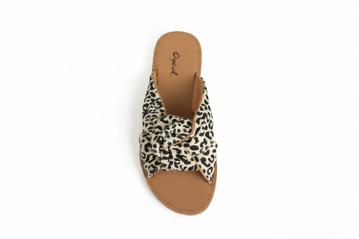 Women's white leopard print slide sandals top view showing cross-strap construction and tan leather footbed