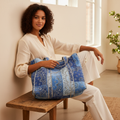 Women's quilted paisley tote bag, model seated in light neutral boutique setting, relaxed lifestyle shot