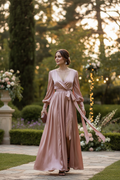 Woman wearing champagne satin wrap dress at wedding reception in garden