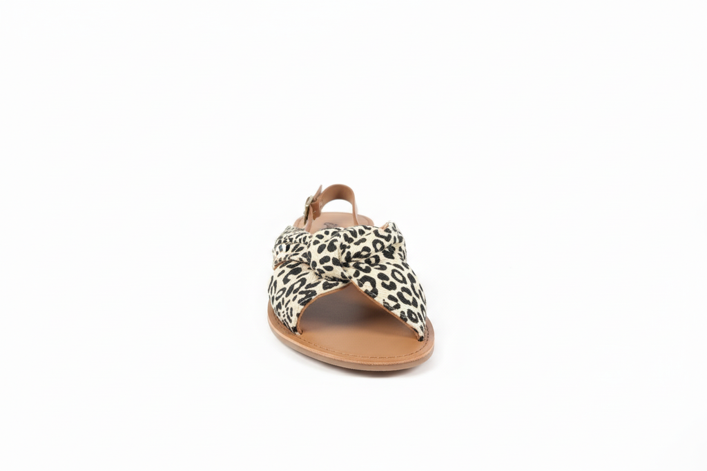 Women's white leopard print slide sandals front view showing cream and black animal print fabric with cross-strap design