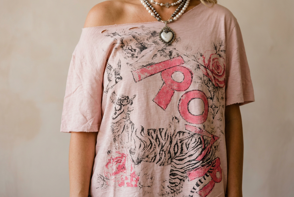 Front print details of a blush pink graphic tee showing a sketched tiger, pink lettering and a pink rose