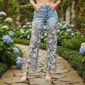 Person wearing light blue jeans with floral lace detailing in a garden setting