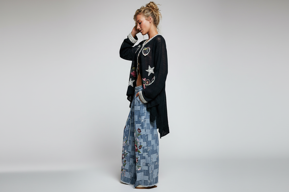 POL Clothing black open-knit cardigan side-profile showing asymmetrical hi-low hem and airy open-knit drape with heart appliqués