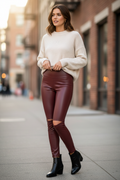 Burgundy Faux Leather Knee Cutout Leggings styled with cream sweater and ankle boots - Lifestyle photo